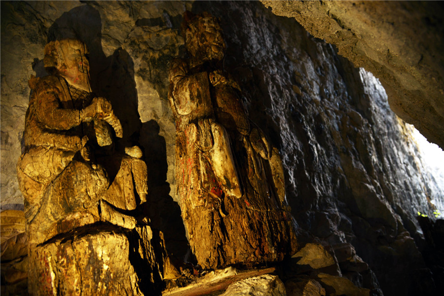 Wood sculptures discovered inside cliffside cave in Chongqing