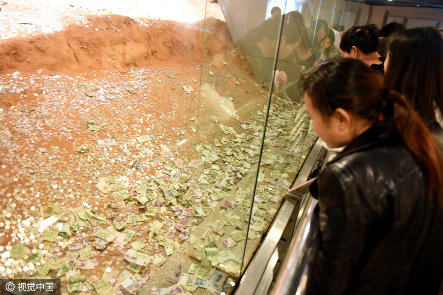 Tourists toss coins at ruins of Leifeng Pagoda