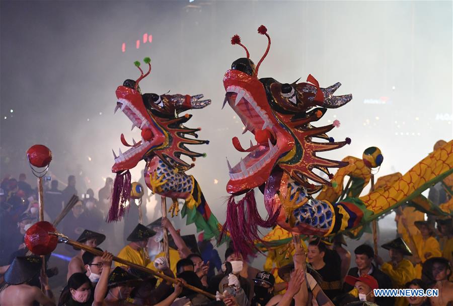 People perform dragon dance in flames of firecrackers in Guangxi