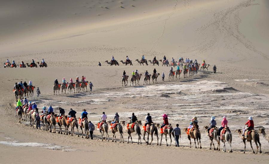 Tourists visit Mingsha Mountain in Dunhuang, NW China