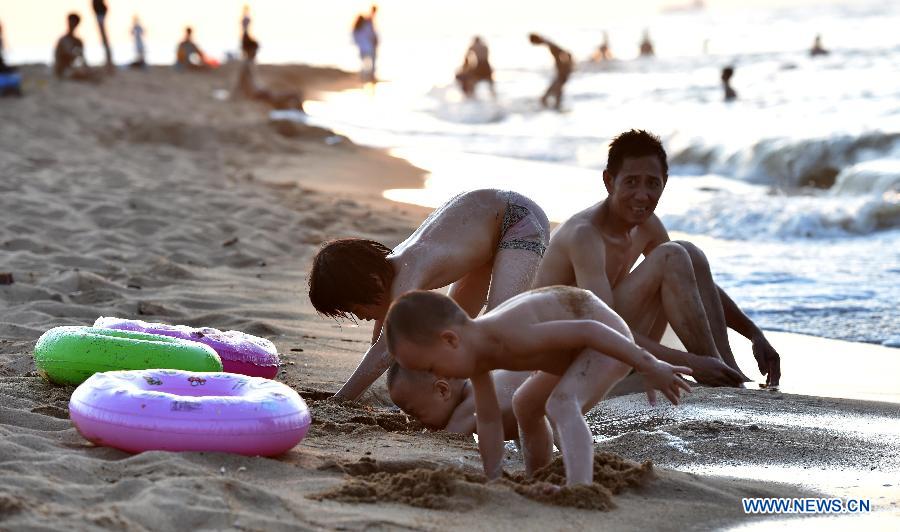 Haikou citizens play along beach in heat wave