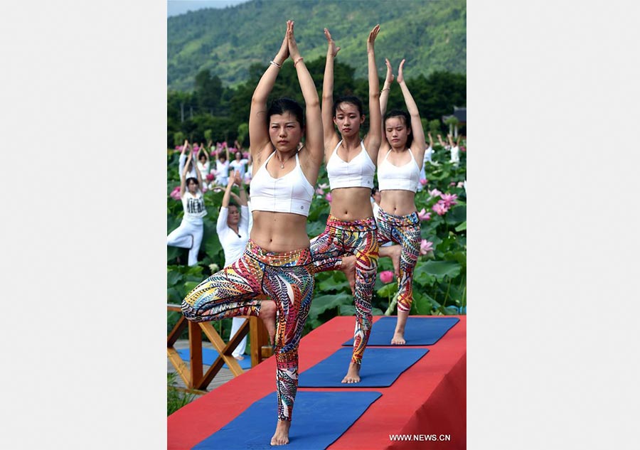 Fans practice Yoga at lotus culture park in SE China's Fujian