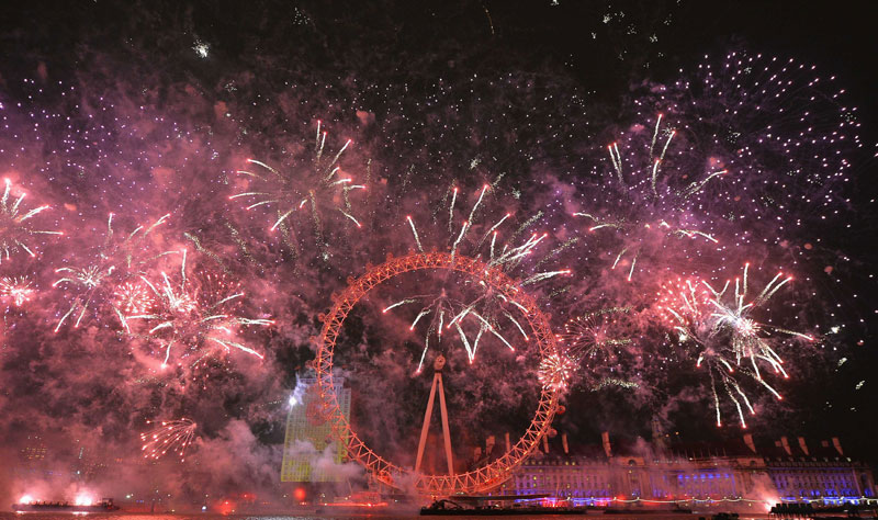 Fireworks explode around the London Eye wheel