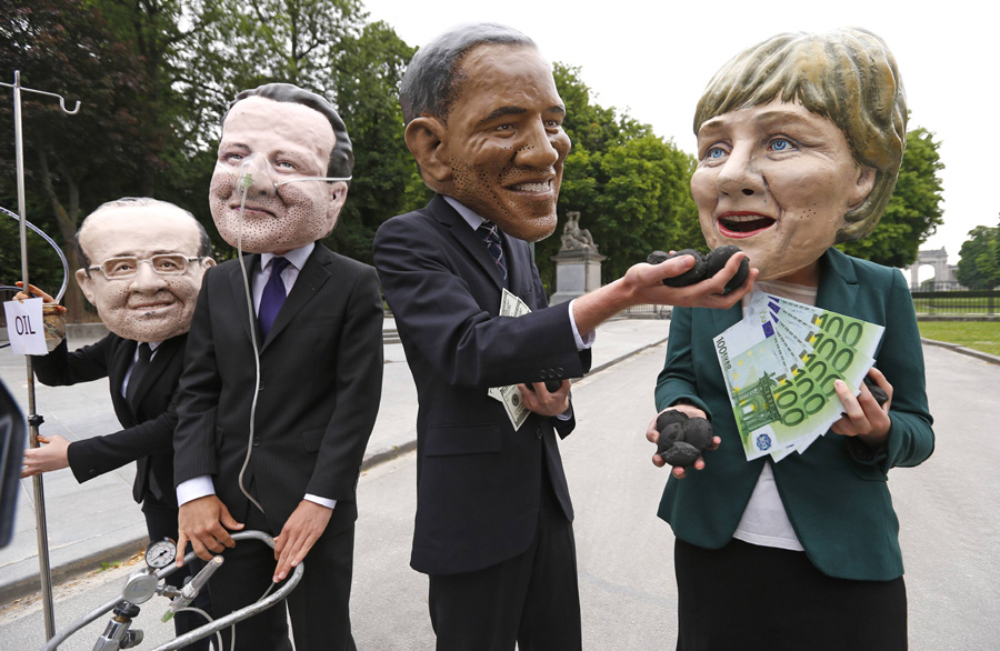 Oxfam demonstrators wearing masks of G7 leaders protest in Brussels